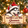 Acrylic ornament of a Husky in a Santa hat with cookie crumbs on its muzzle, lying on a scroll that reads Naughty List 2026, Gunner, Ate Santa's cookies